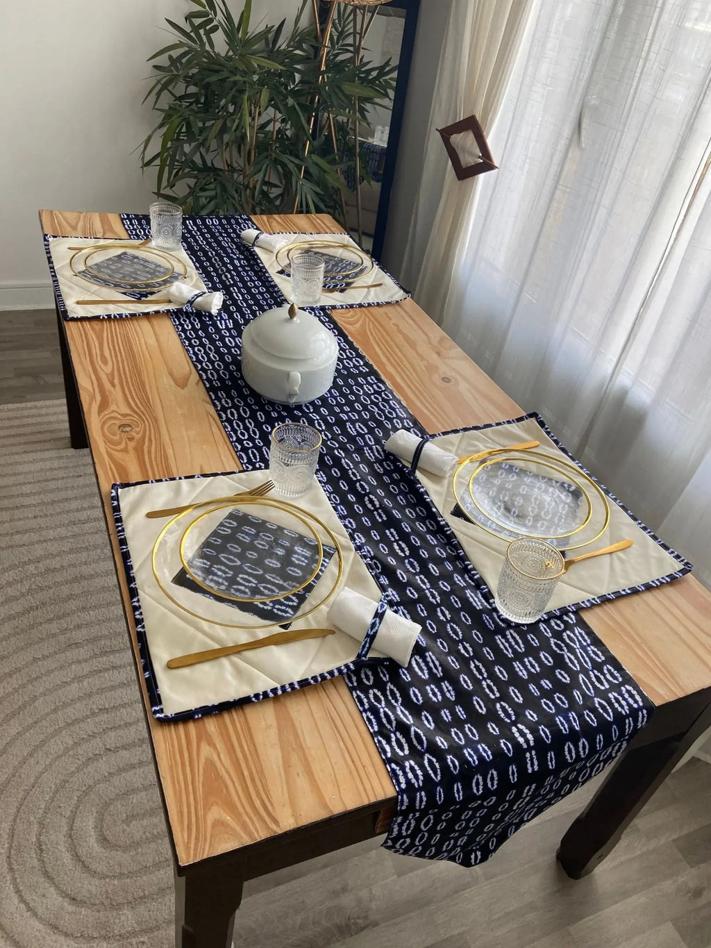 Chemin de table élégant de la collection TITA par Keur Nani, disposé sur une table en bois chaleureux. Son design raffiné et ses motifs délicats apportent une touche de sophistication et de charme à votre espace de repas, parfait pour recevoir avec style.